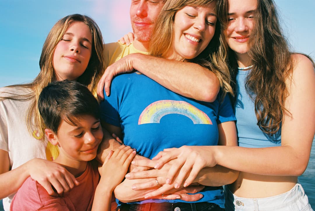 family portrait shots on maui in beach and ocean full of happiness and joy and color at beach and in calm ocean