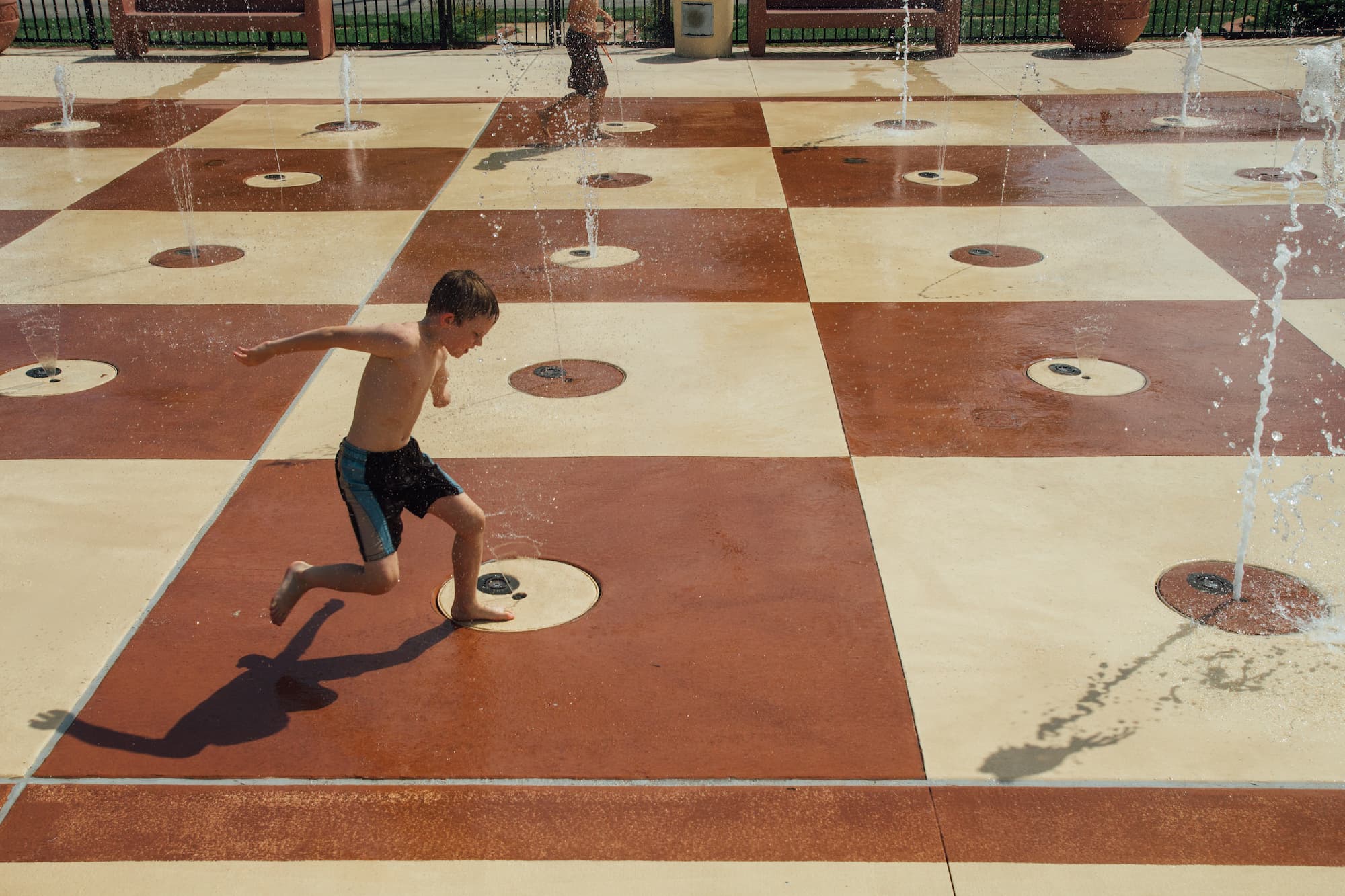 Child playing in a splash pad water park during summertime in the Midwest. Musick Park, Hazelwood St. Louis Missouri, USA.