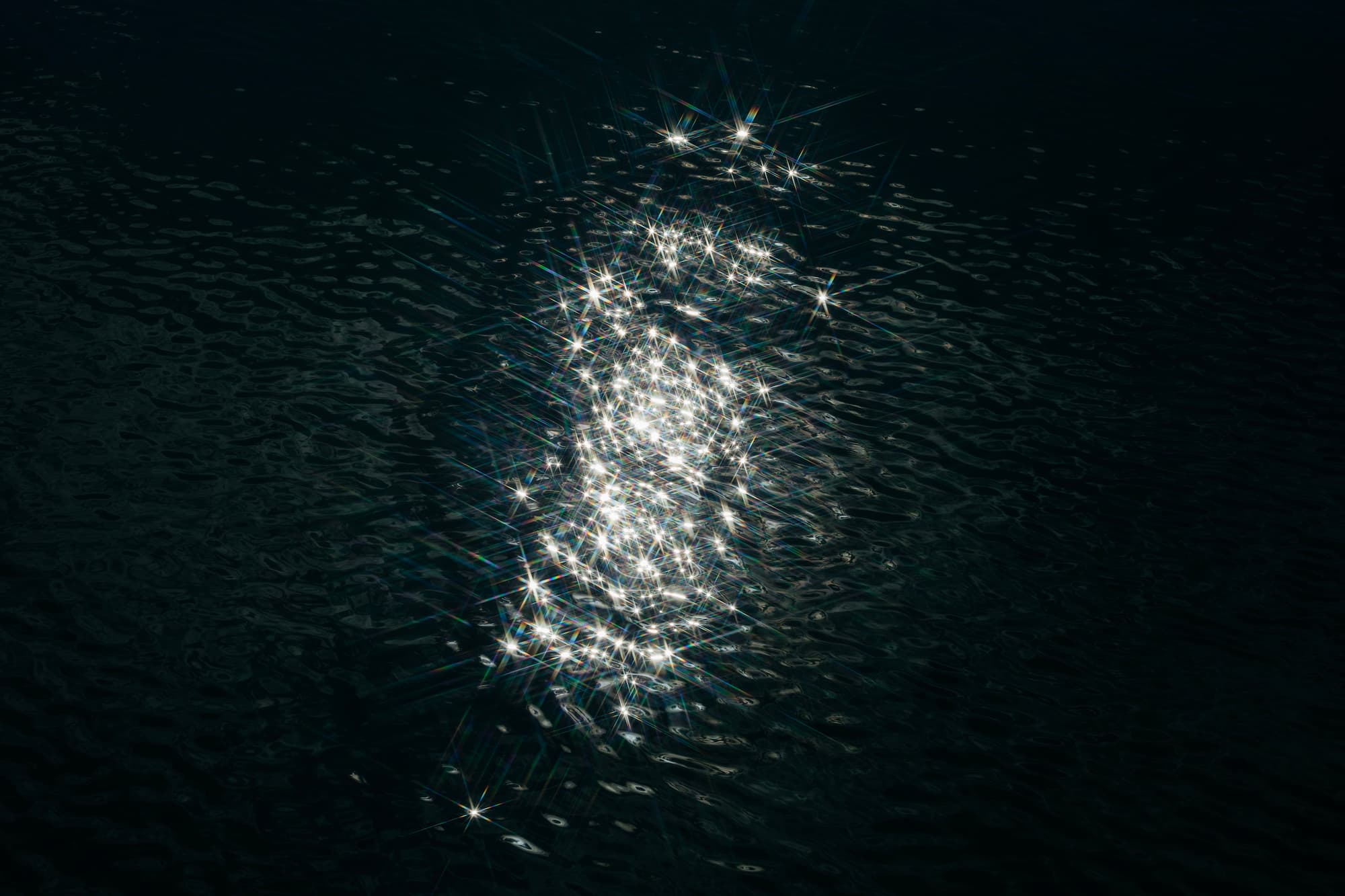 Sun reflection with stars on dark water