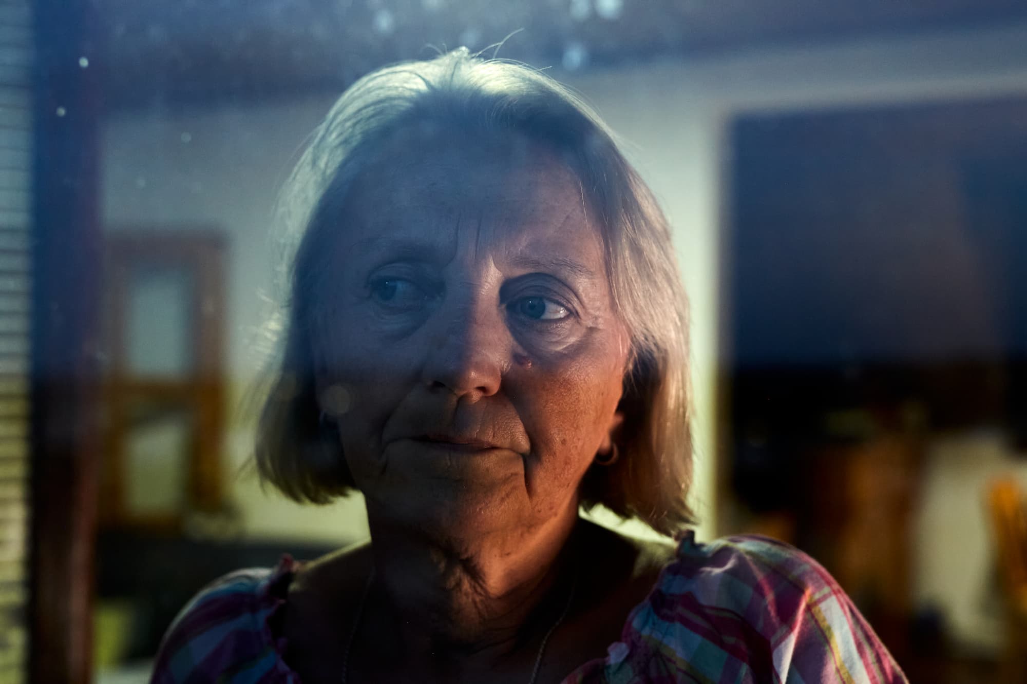 Portrait through glass of a woman thoughtfully looking away