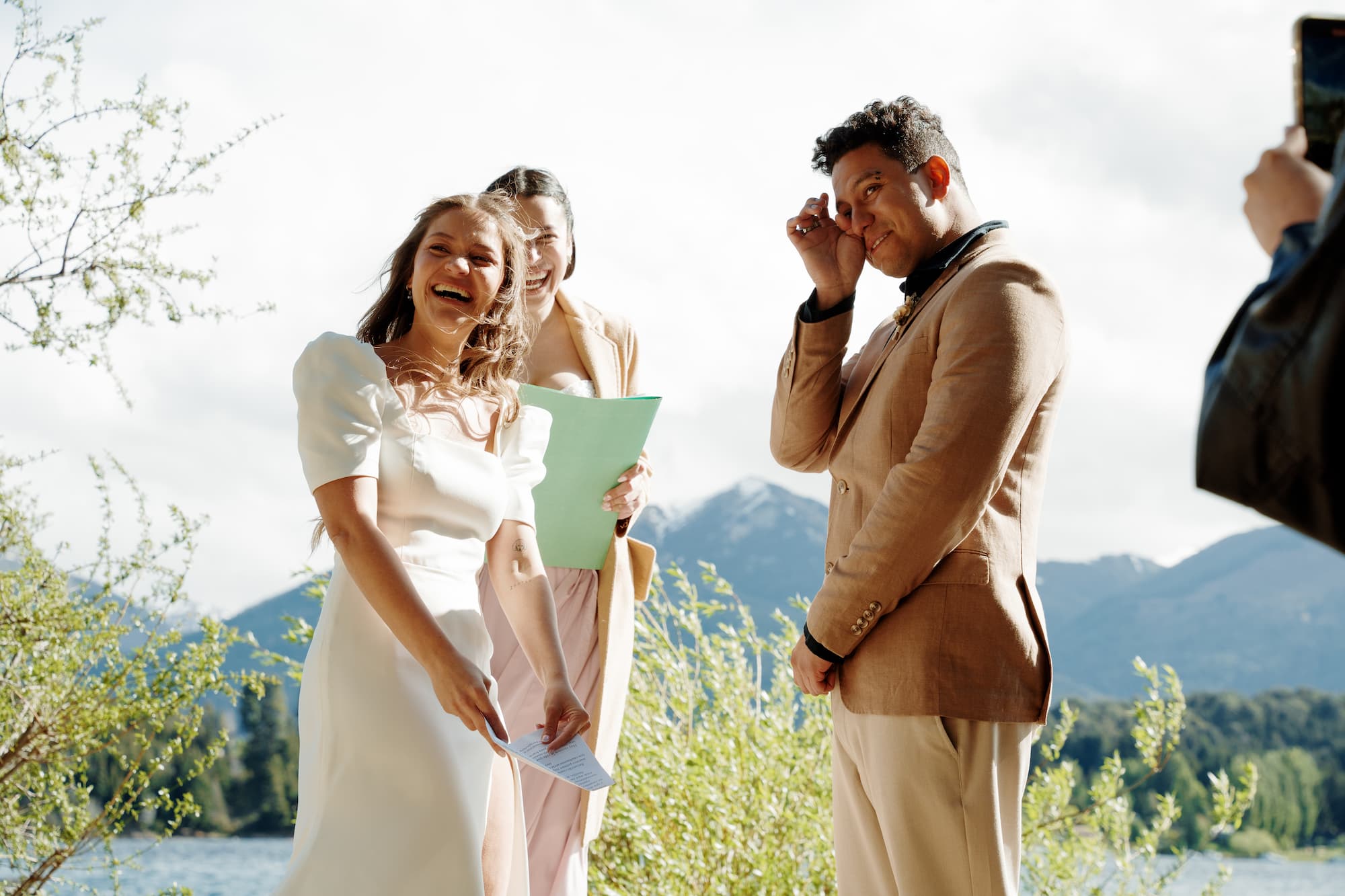 wedding scene in nature, the bride is reading her vows to the groom and he is moved