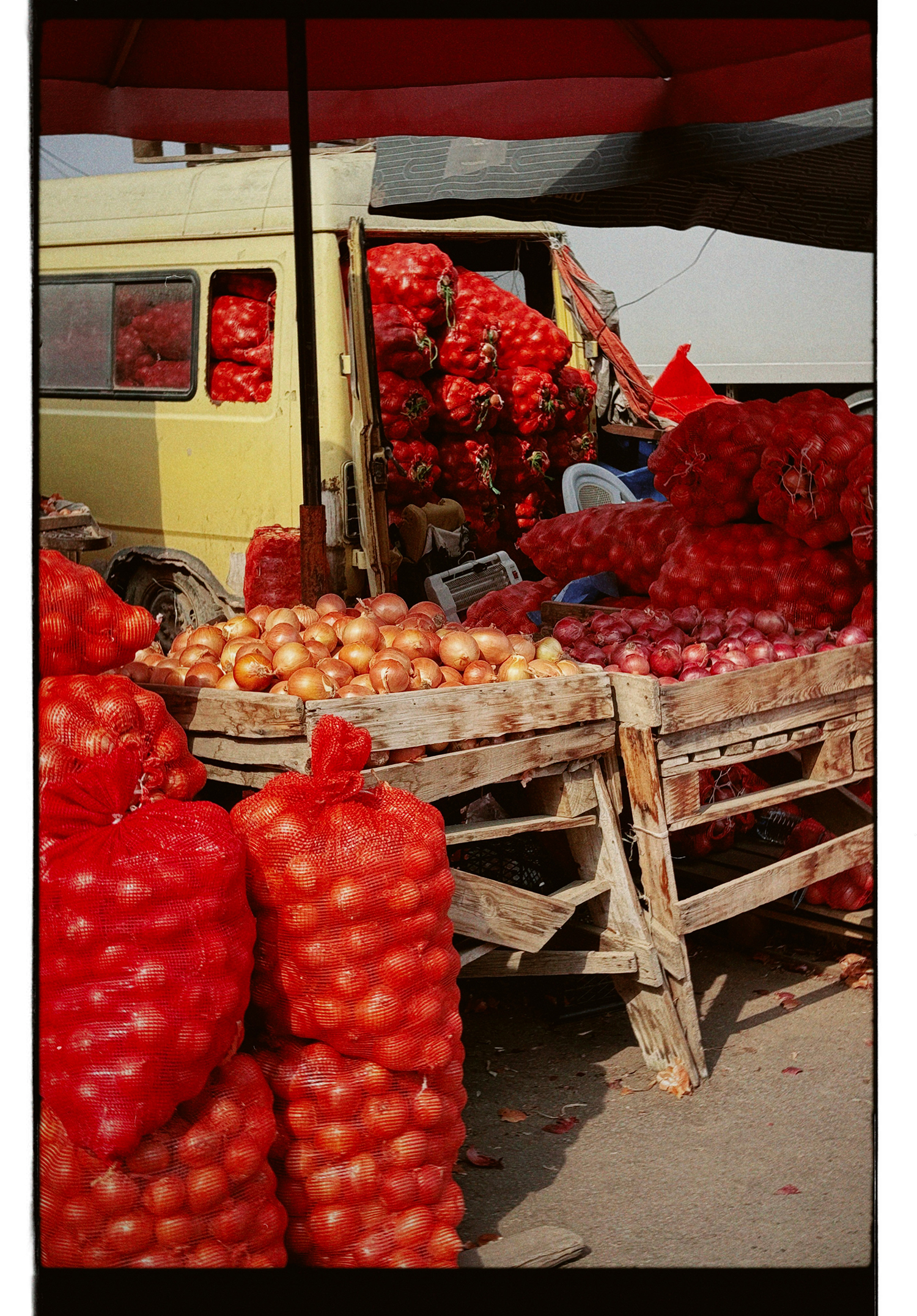 Market stall with onions and red mesh bags Vibrant market scene showing a van loaded with onions in red mesh bags