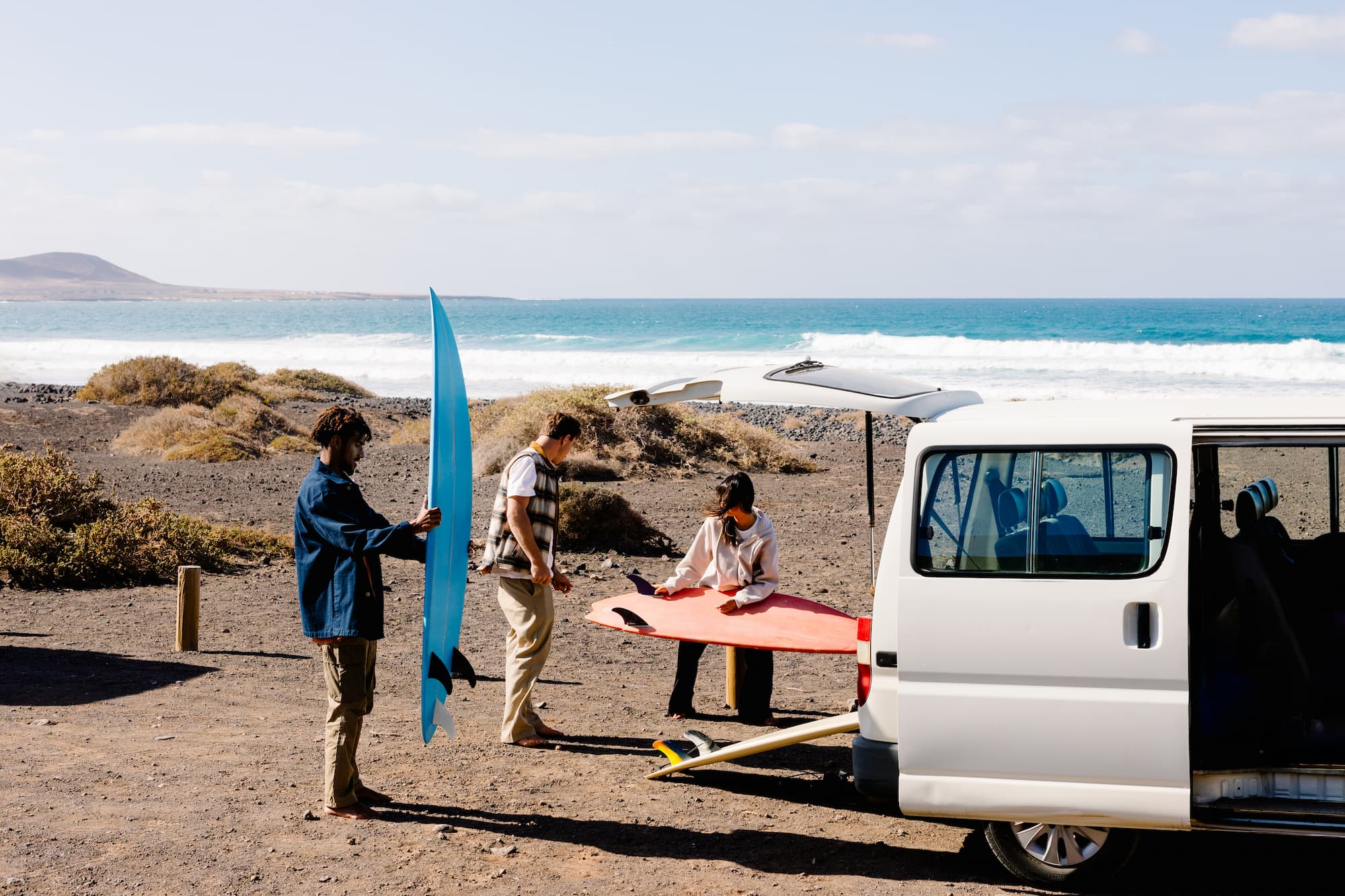 A mixed group of surfing companions reaching the beach
