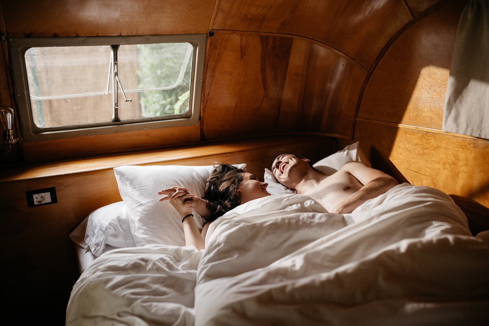Young cute couple enjoying time together at bed He is laughing