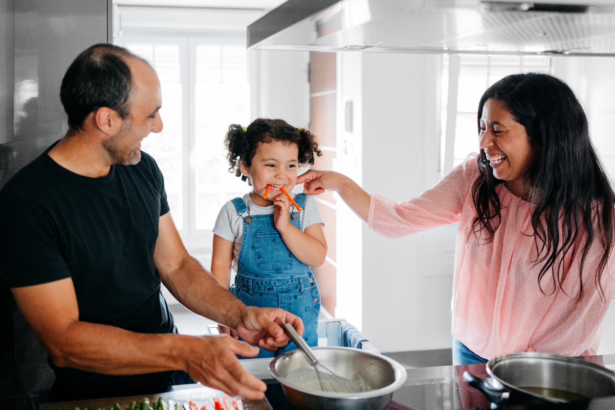 Happy family cooking vegan food at home Multiethnic family preparing vegan food at the kitchen