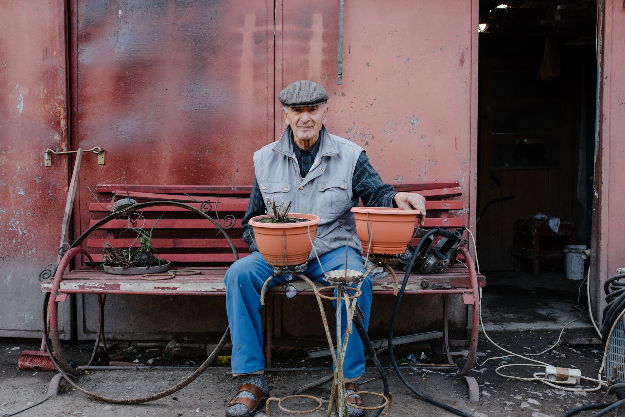 Elderly Man With Flower Stand Elderly man making a metallic flower stand