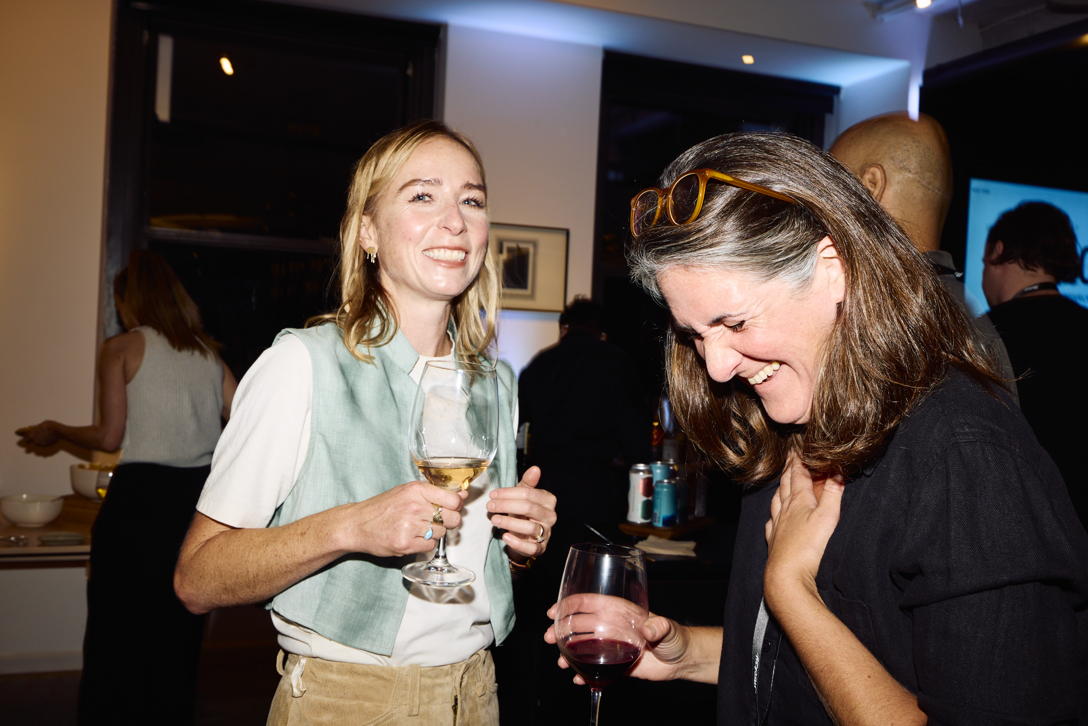 2 women laughing together at Stocksy's Signs of Life event reception