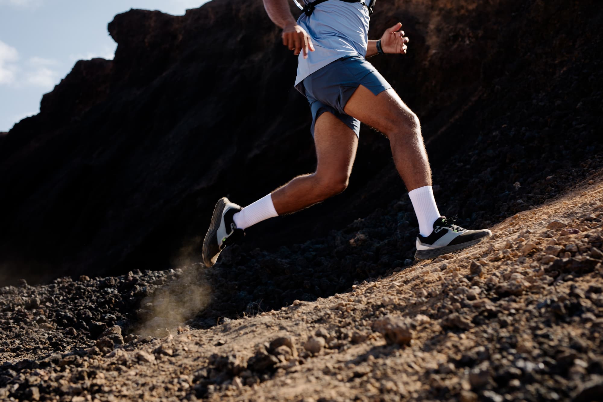 The legs of an anonymous professional hiking athlete as he runs across a volcano during a morning training session in Lanzarote, Canary Islands.