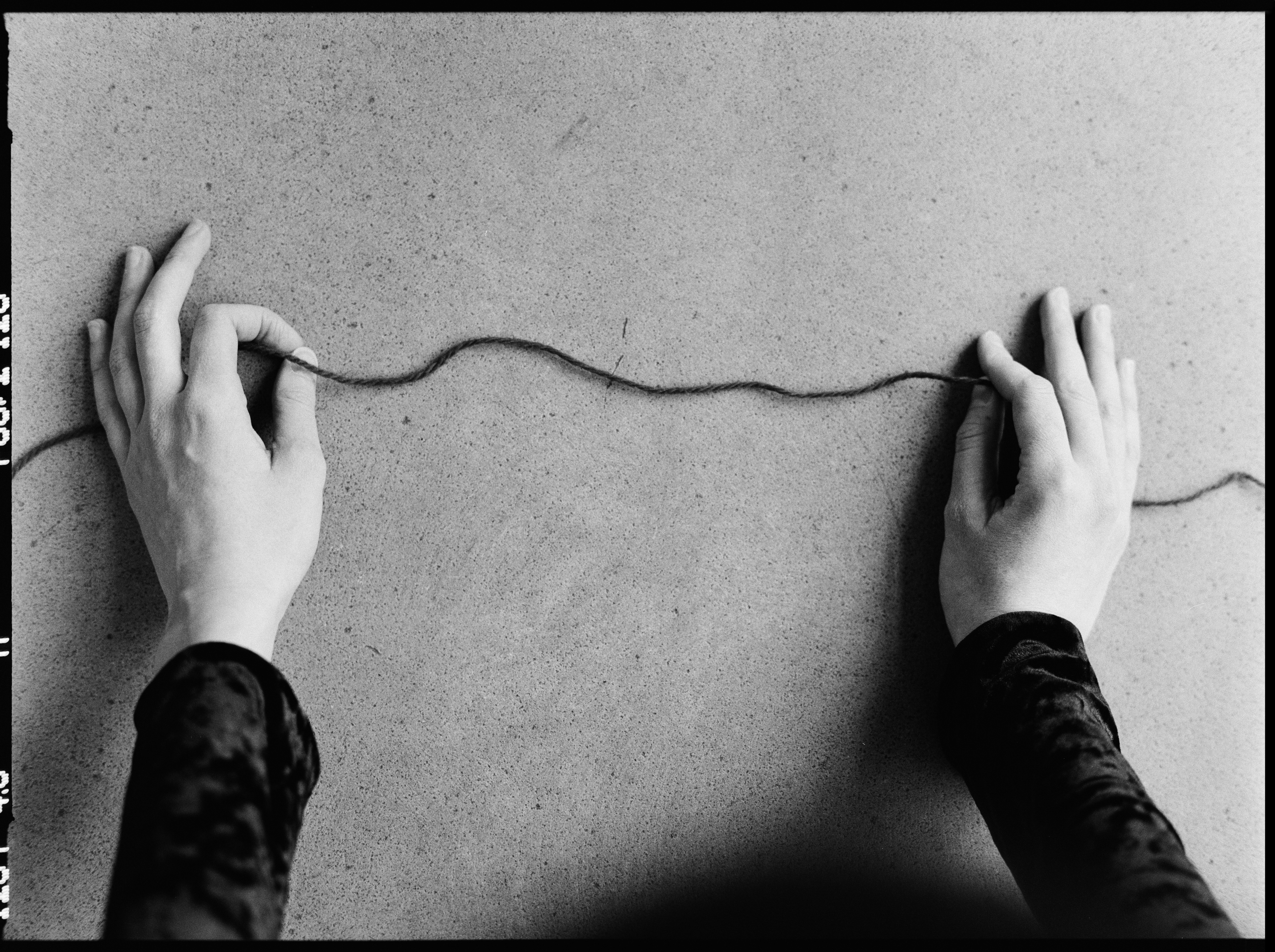 young woman holding thread in her hands, close-up